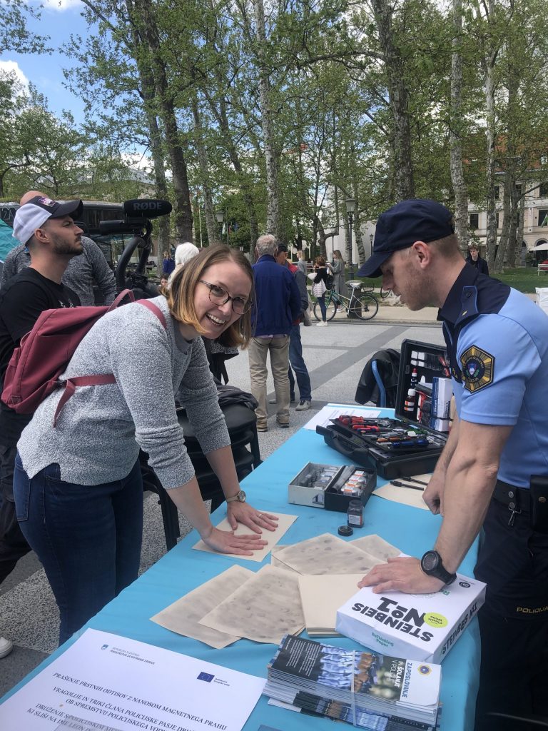 Obiskovalka na stojnici za odkrivanje prstnih odtisov na dogodku ob Dnevu Evrope