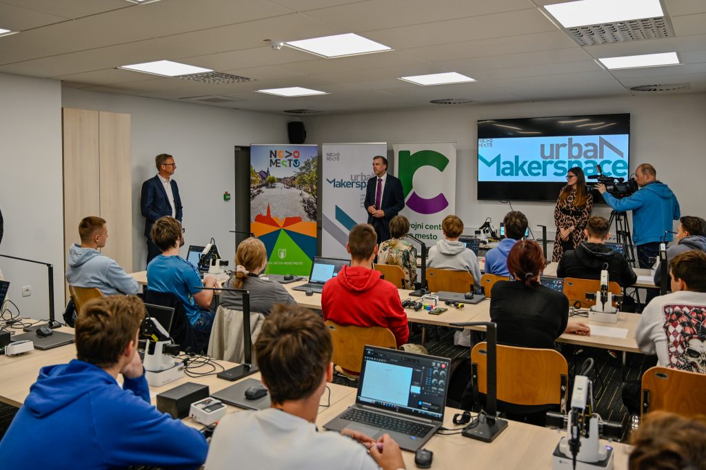 Dogodek projekta UrbanMakerSpace. Ljudje v dvorani, poslušajo.