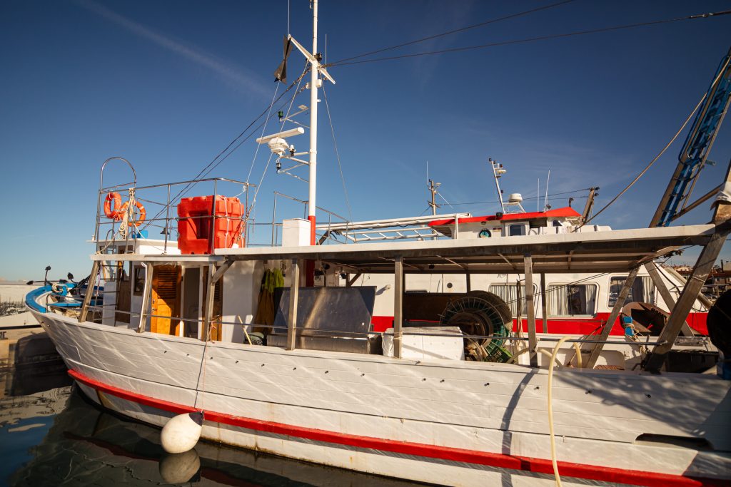 Ribiško plovilo, privezano v ribiškem pristanišču.