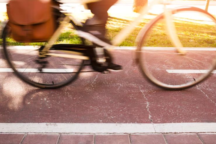 Bližnji posnetek kolesa na kolesarski stezi v gibanju.