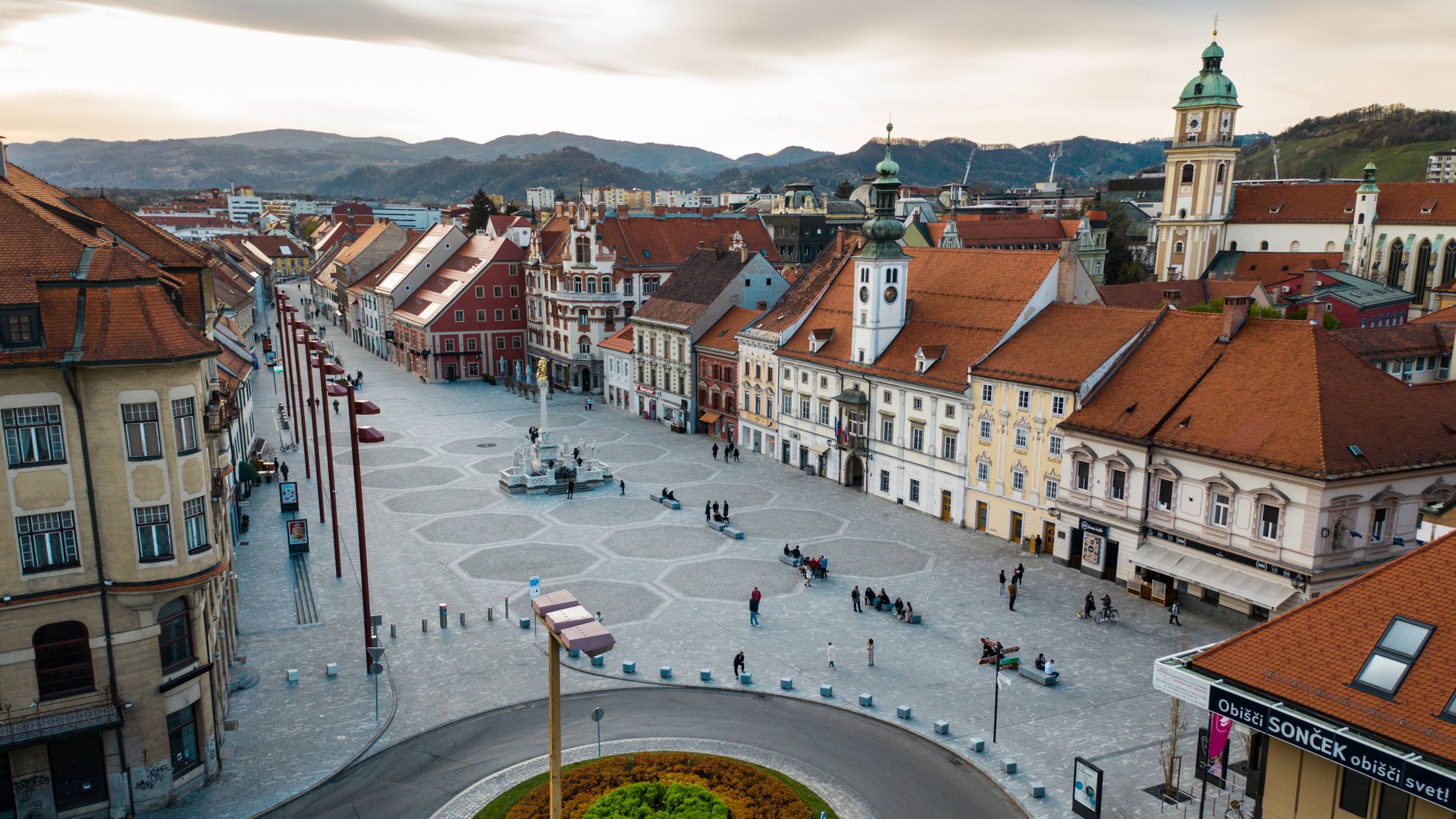 Posnetek osrednjega trga s stavbami v Mariboru s ptičje perspektive.